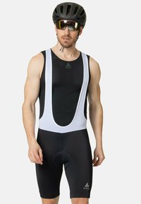 Shorts de cyclisme noires et blanches avec un haut en mesh, dotés d'une chamois rembourrée, d'un logo sur la jambe et d'un ajustement serré pour le confort et le soutien.