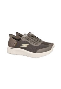 Zapatillas deportivas de malla gris con una suela blanca, con un diseño de cordones y detalles de logotipo en el lateral y la lengüeta.