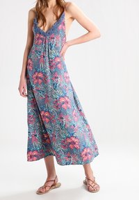 Robe maxi florale bleue avec des motifs tropicaux roses et verts. Décolleté en V avec bordure en dentelle, tissu fluide et longueur jusqu'aux chevilles.