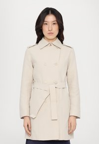 Trench coat bej cu un design structurat, cu un guler dublu, epauleți pe umeri și o curea din material. Textură netedă, mâneci lungi.