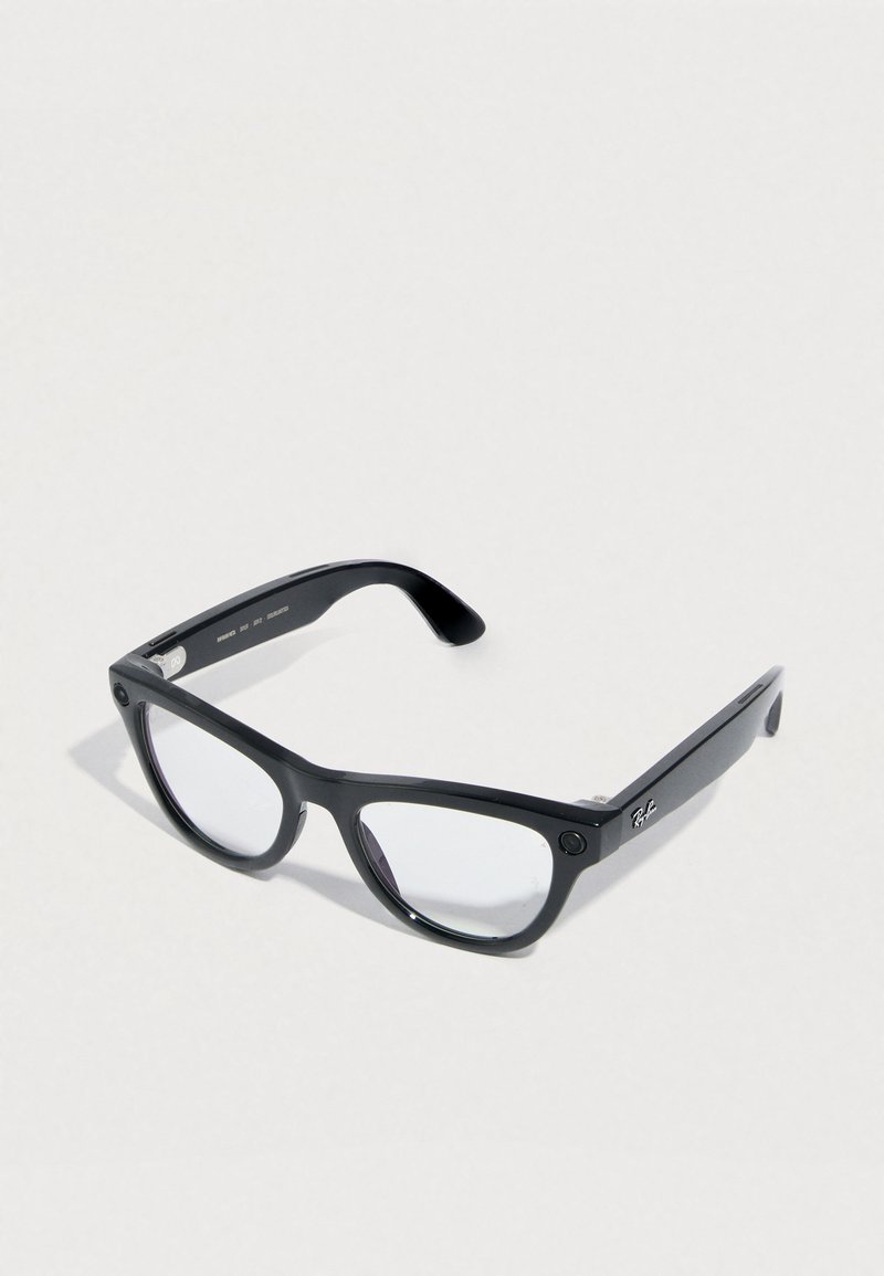 Lunettes noires de forme rectangulaire, en plastique brillant. Verres transparents, avec un détail de logo subtil sur les branches.