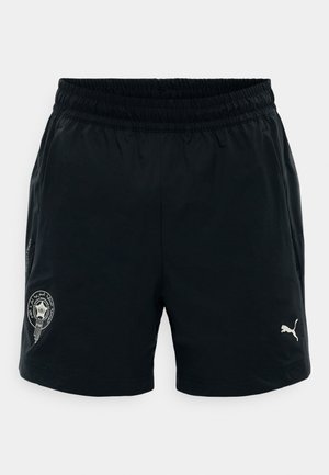 Melni sporta šorti ar elastīgu jostu, sānu kabatām, baltu Puma logotipu uz labās kājas un apaļu emblēmu uz kreisās kājas.