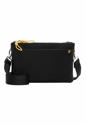 Must ristkott reguleeritava rihmaga, kollase tõmblukuga, ees tasku ja väike logo silt valgel taustal.