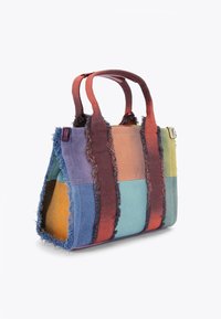 Multikleurige stoffen boodschappentas met rafelige randen, voorzien van oranje, blauwe, groene en paarse patches. Twee stevige handvatten voor het dragen.
