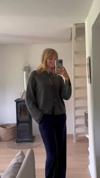 Γκρι πλεκτό cardigan με στρογγυλή κολάρο και μπροστινές κορδέλες, σε συνδυασμό με ναυτικές παντελόνες. Λείος υφασμάτινος χαρακτήρας, χαλαρή εφαρμογή και μακριά μανίκια.