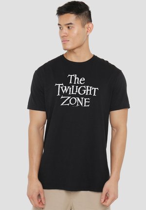 Black cotton t-shirt featuring "The Twilight Zone" logo in white, short sleeves, crew neck, and a relaxed fit. Classic casual design.