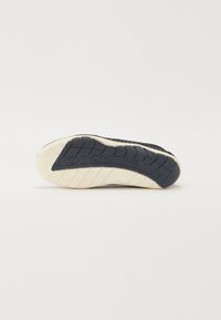 Must musta sneakeri taldil on tekstureeritud mustri disain. "TOM TAILOR" logo on pealiskihil reljeefne, koorevärvi äärtega detailid.