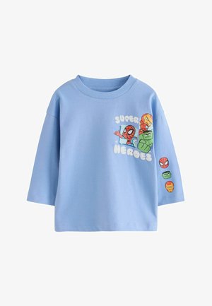 Ljusblå, kortärmad bomullströja med färgglada superhjälte-grafiker och texten "SUPER HEROES" på framsidan samt karaktärsansikten på ärmen.