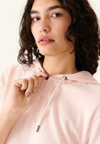 Lichtroze hoodie met een halve rits, voorzien van een trekkoord en hardware in zilvertint. Zachte stof met een casual pasvorm.