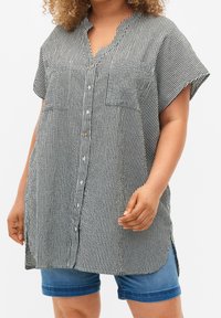 Black and white striped button-up shirt with a short collar, two front pockets, and rolled short sleeves; textured fabric with a loose fit.