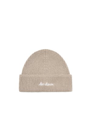 Beige strikket lue med ribbestruktur og brettet oppkant. Har hvit brodert tekst foran.