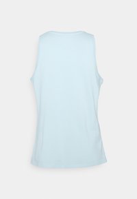 Vaaleansininen hihaton paita, joka on valmistettu pehmeästä puuvillasta. Ominaisuutena on pyöreä kaula-aukko ja hieman väljä leikkaus ilman lisätietoja tai kuvioita.