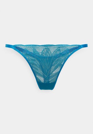 Blonde-tanga i grønnblå med blomsterpattern og halvgjennomsiktige detaljer. Justerbare stropper og bred, elastisk linning for en behagelig passform.