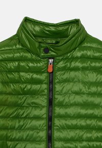 Veste rembourrée verte avec un col haut, dotée d'une fermeture éclair et d'une tirette orange. La surface a une texture lisse et brillante avec des coutures horizontales.