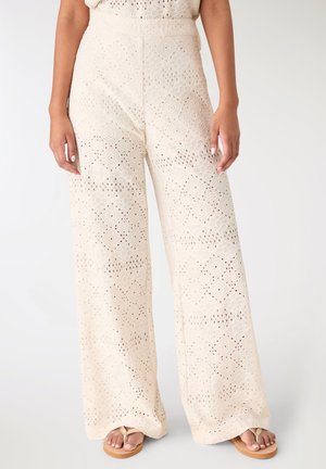 Pantaloni a gamba larga realizzati in tessuto leggero ricamato di colore bianco sporco, con motivo a diamante e superficie testurizzata.