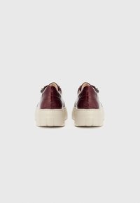 Baskets en cuir bordeaux avec une finition texturée, semelle plateforme crème, fermeture éclair à l'arrière et design à bout rond.