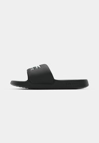 Sort gummislidersandal med en bred rem, der har LCST-tekst. Glat mat overflade, flad sål, og brandlogo præget på siden.