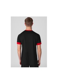 T-shirt de sport noir avec un col et des accents de manches rouges, présentant une texture lisse et une coupe décontractée, conçu pour être porté lors d'activités.