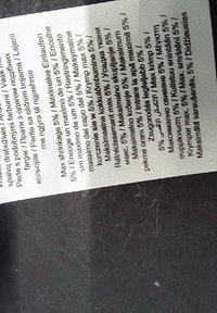Pflegeetikett aus Stoff mit mehrsprachigem Text auf weißem Hintergrund. Enthält Waschhinweise und Angaben zur Materialzusammensetzung.