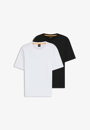 Dwie koszulki w kolorze czarnym i białym, wykonane z bawełny. Obie mają okrągłe dekolty, krótkie rękawy oraz subtelne detale z logo przy szyi.