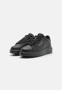 Sneakers in pelle nera con punta arrotondata, colletto imbottito e suola in gomma spessa. Presentano una linguetta texturizzata e accenti con logo sui lati.