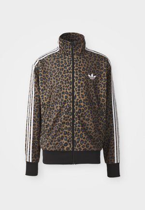 Brązowa i czarna kurtka zapinana na zamek w panterkę, z białymi akcentami w postaci trzech pasków na rękawach oraz czarnym ściągaczem u dołu. Klasyczne logo Adidas.