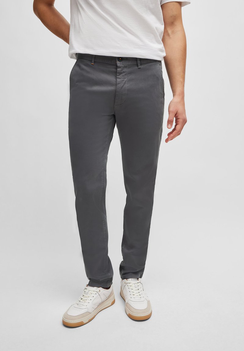 Grå chinos i bomullsblandning med slim fit, med frontfickor, midjeband med bälteslussar och kontrasterande knappdetaljer.