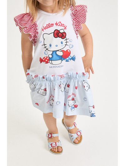 Νήπιο που φοράει λευκό φόρεμα με μανίκια βολάν με κόκκινες ρίγες και τύπωμα Hello Kitty, συνδυασμένο με ανοιχτό μπλε σανδάλια με σχεδιασμούς κινουμένων σχεδίων.