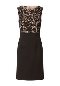 Robe noire avec un corsage ajusté orné d'une délicate superposition de dentelle noire et une jupe noire unie. Fermeture éclair au dos, design sans manches.