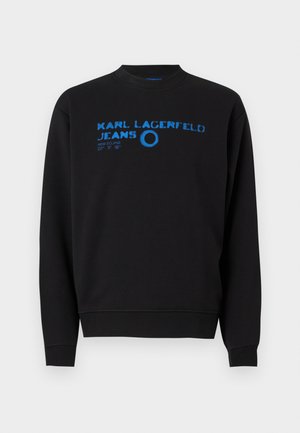 Melnā džemperis ar apaļu kakla izgriezumu, garām piedurknēm un zilu grafisku tekstu ar zīmola nosaukumu un dizaina detaļām uz priekšpuses.