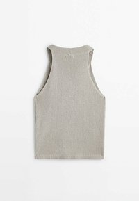 Gilet sans manches en tricot beige avec un col montant et des bords côtelés, posé à plat sur un fond blanc.