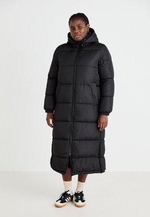 Black long padded coat with a hood, front zipper, and elastic cuffs. Features a vertical quilted design and side pockets.