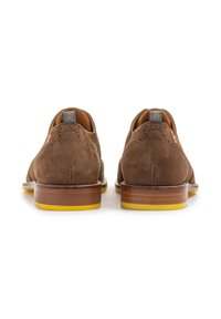 Bruine suède schoenen met een lage snit, een gladde houten hak en een gele rubberen zool. Heeft brogue-details op de achterkant.
