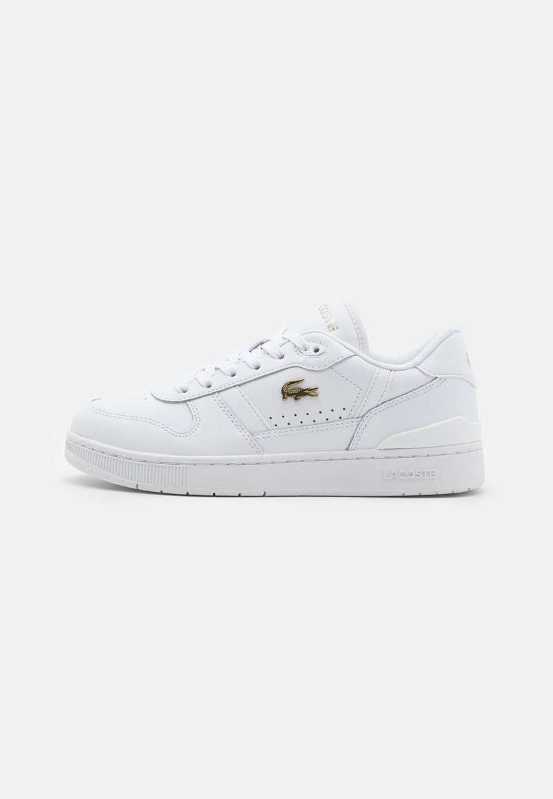 Białe skórzane sneakersy o gładkim wykończeniu, okrągłym nosku, perforowane boki dla lepszej wentylacji oraz złote logo Lacoste po zewnętrznej stronie.
