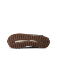 Brown rubber sneaker sole with a textured grip pattern and a circular logo. Features a slight indentation and a neutral design.