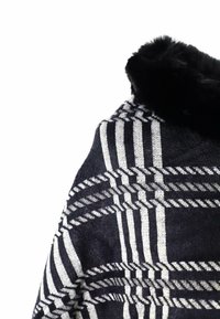 Maglione a coste bianche e nere a motivo, con strisce verticali e diagonali, dotato di un colletto in pelliccia sintetica nera per un tocco di texture.