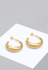 Boucles d'oreilles en or à ton chaud avec un design incurvé, une texture lisse et un fermoir sécurisé. Chaque boucle d'oreille présente un petit diamètre et une surface réfléchissante.
