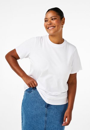 Weißes Kurzarm-T-Shirt aus Baumwolle mit klassischem Rundhals und lässiger Passform, kombiniert mit einem Jeansrock.