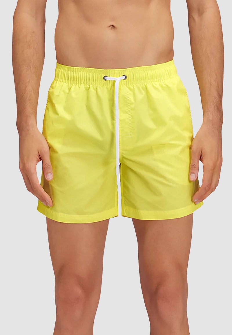 Costumi da bagno gialli brillanti realizzati in materiale leggero. Presentano una vita elastica con cordino e cuciture laterali.