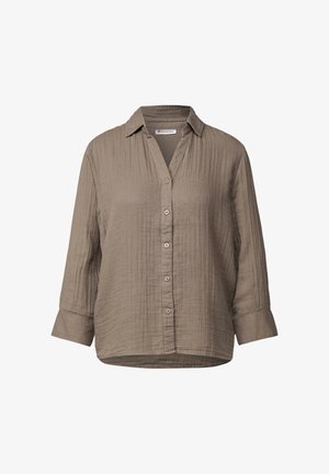 Skjorta i mjuk, texturerad olivgrön tyg, med krage och långa ärmar med knappmanschetter. Rak fåll med subtila veck.