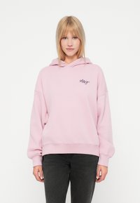 Hele roosa ülemõõdustatud kapuutsiga pusa pehmest kangast, millel on nööriga kapuuts, soonikkoes mansetid ja rindkeres väike tikandiga logo.