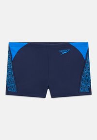 Morske plavalne hlače z modrimi detajli, teksturiranim stranskim vzorcem in logotipom "Speedo". Narejene iz gladkega, raztegljivega materiala za udobje.
