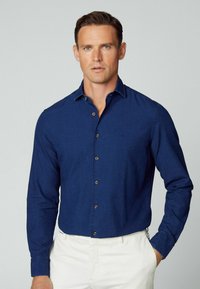 Camicia button-up blu scuro realizzata in tessuto leggero, con colletto, maniche lunghe e bottoni a contrasto. Design semplice senza motivi.