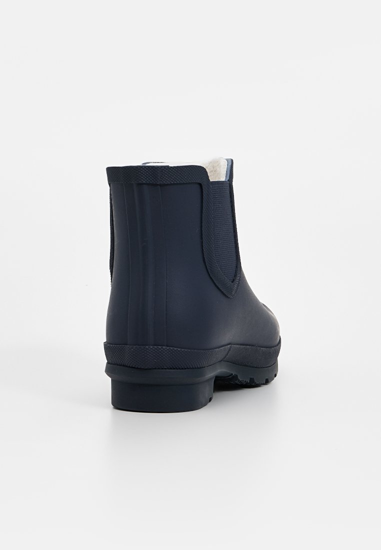 Botte de cheville en caoutchouc bleu marine avec surface texturée, panneaux latéraux élastiques et doublure douce. Dispose d'une semelle en caoutchouc durable avec adhérence.