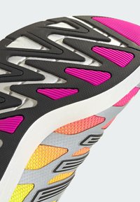 Lightweight sneaker with a textured black rubber sole, vibrant pink and orange accents, and a gray mesh upper featuring a patterned design.