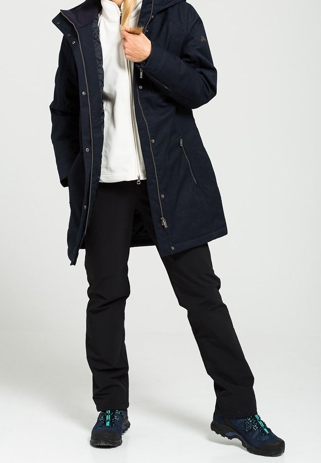 Navy waterproof coat with a hood, zipper, and pockets, paired with black pants and dark shoes featuring teal accents. Smooth texture.