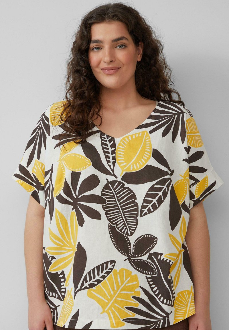 Witte blouse met korte mouwen en een V-hals, versierd met een gedurfde blaadjesprint in geel en bruin. Gemaakt van lichtgewicht stof, heeft het een ontspannen pasvorm.