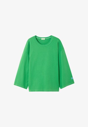 Chemise verte à manches longues avec col rond, manches larges et couture visible le long de l'ourlet et des poignets.