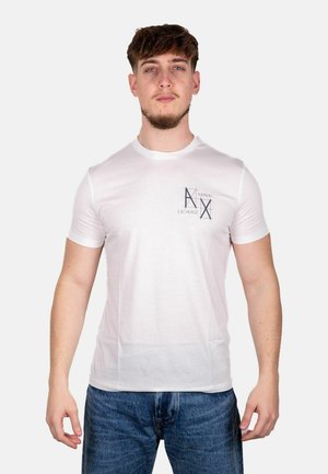 T-shirt bianca in cotone con collo rotondo, maniche corte e stampa grafica che presenta "Armani Exchange" in blu scuro sul petto sinistro.