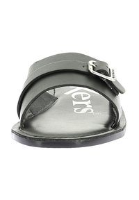 Sandale à glissière en cuir noir avec une large sangle, accent de boucle en argent, bout arrondi et semelle plate avec une semelle intérieure texturée.